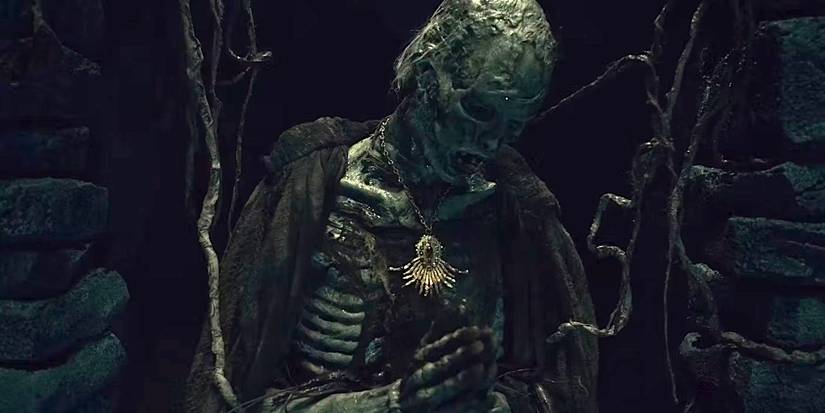 Cena de 'Gabinete das Curiosidades' com um cadáver em um cemitério.