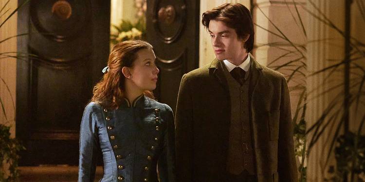 Enola Holmes (Millie Bobby Brown) and Tewkesbury (Louis Partridge) looking at each other in Enola Holmes 2