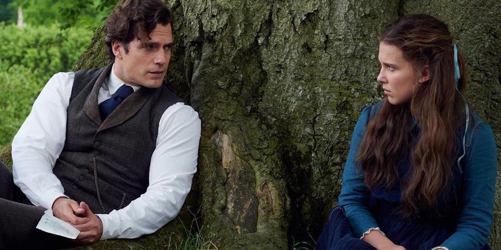 Henry Cavill as Sherlock talking to Millie Bobby Brown as Enola leaning against a tree in Enola Holmes 2.