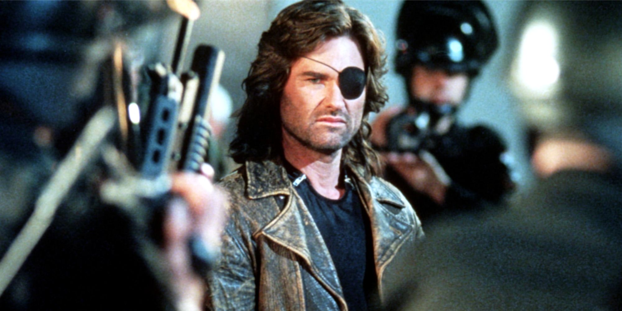 Kurt Russell surrounded by soldiers fleeing New York wearing an eye patch with long hair