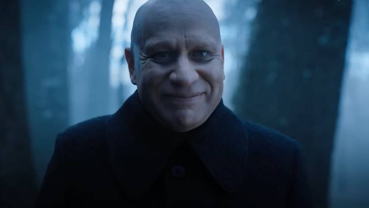 Fred Armisen as Uncle Fester smiling in Wednesday.