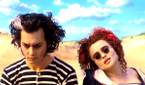 Helena Bonham Carter as Nellie Lovett and Johnny Depp as Sweeney Todd sitting at the beach in Sweeny Todd: The Demon Barber of Fleet Street