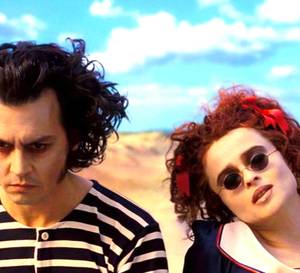 Helena Bonham Carter as Nellie Lovett and Johnny Depp as Sweeney Todd sitting at the beach in Sweeny Todd: The Demon Barber of Fleet Street