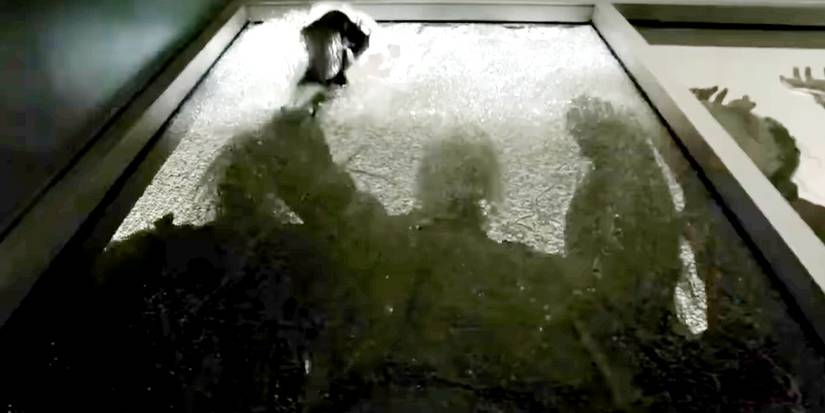 A variant zombie smashes glass with a rock in The Walking Dead.