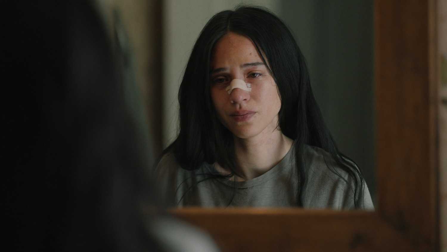 Monica Dutton (Kelsey Asbille) looking at her injured face in the mirror in Yellowstone season 5 episode 2