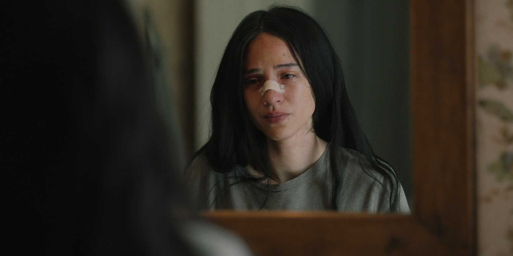 Monica Dutton (Kelsey Asbille) looking at her injured face in the mirror in Yellowstone season 5 episode 2