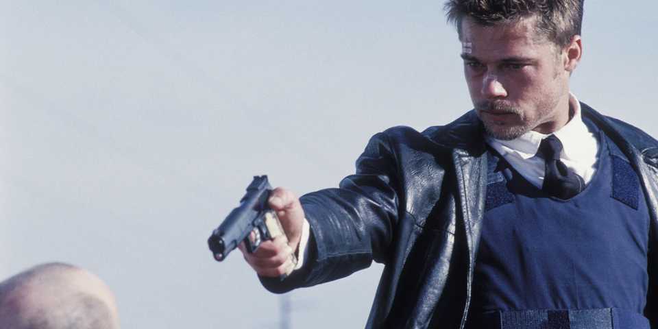 Brad Pitt as Mills aiming a gun at John Doe in Se7en