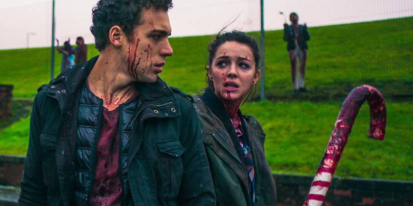 Anna (Ella Hunt) e John (Malcolm Cumming) lutando contra zumbis em Anna and the Apocalypse