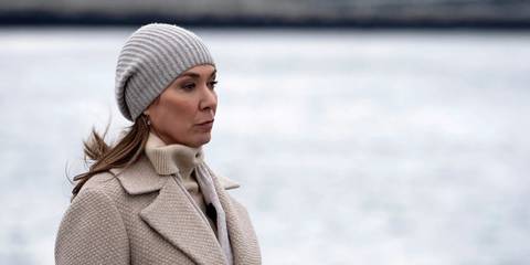 The Major from Manifest standing by the water, looking pensive.