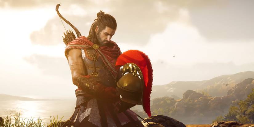 Alexios kneels and looks at the Spartan helmet in Assassin's Creed Odyssey.