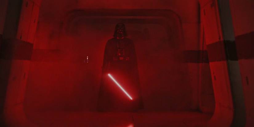 Darth Vader holding his lightsaber surrounded by red light in Rogue One: A Star Wars Story.