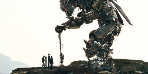 Jetfire standing over humans on a cliff in Transformers Revenge of the Fallen 
