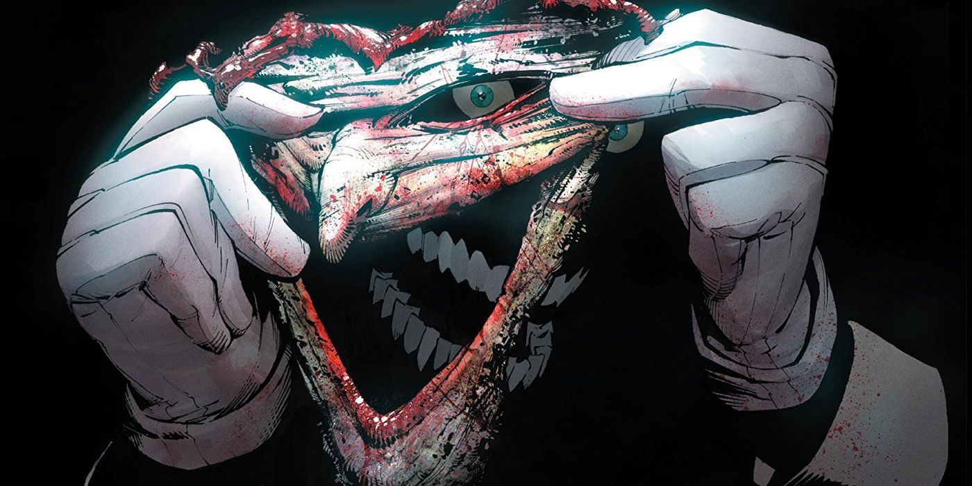 Joker holding up his bloody carved-off face while wearing pristine white gloves.