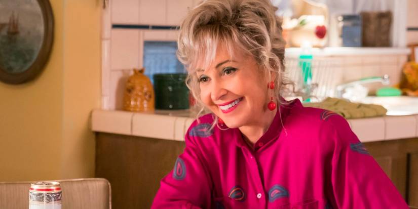 Meemaw (Annie Potts) smiling at the table in Young Sheldon