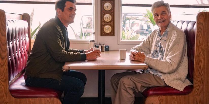 Phil and Frank sitting at a restaurant table on Modern Family