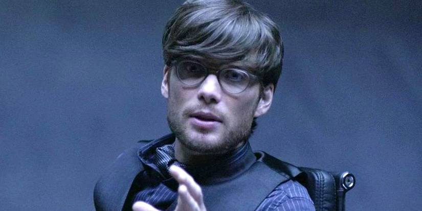 Cillian Murphy as Edward Dillinger Jr holding his hand up in Tron: Legacy