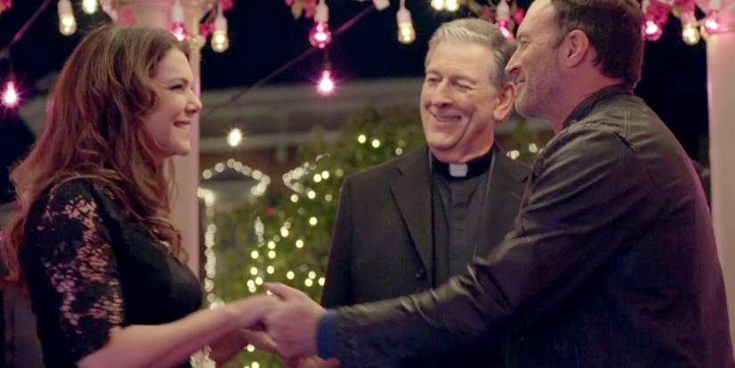 Lorelai and Luke holding hands and smiling at their wedding in Gilmore Girls: A Year in the Life.