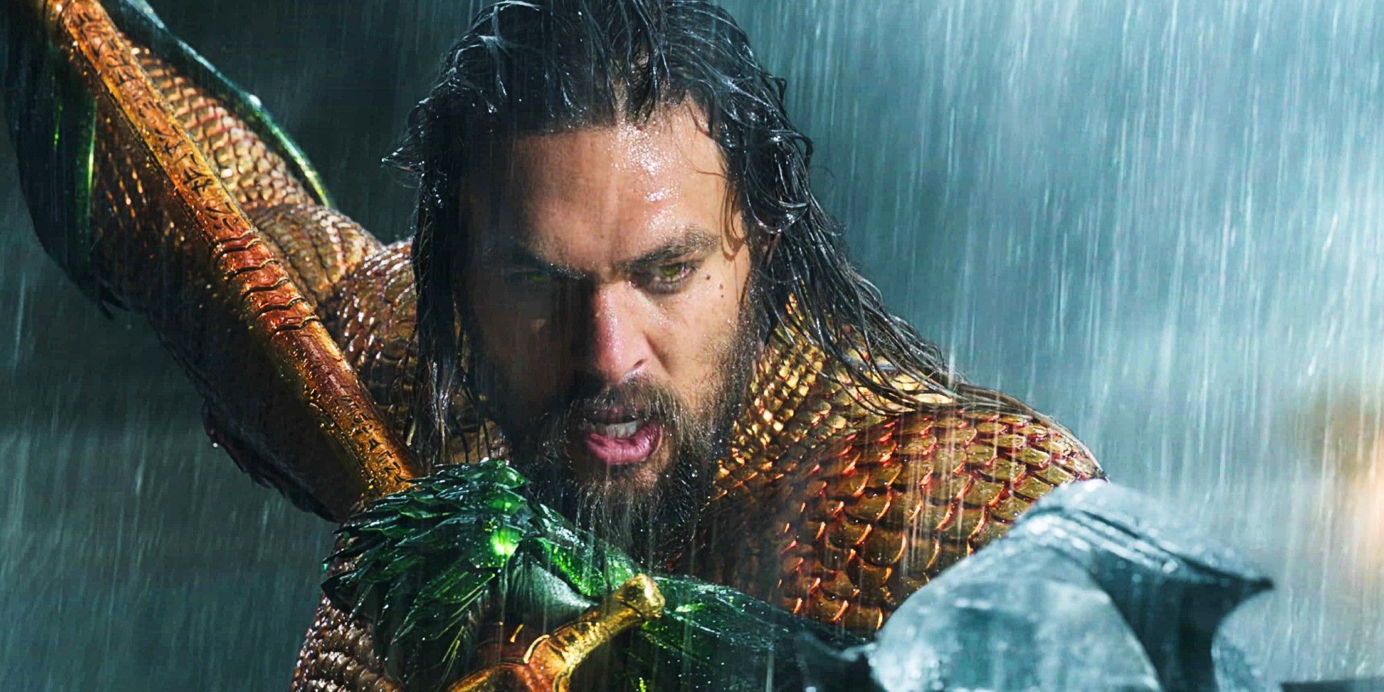 Jason Momoa Aquaman holding his trident in the rain.