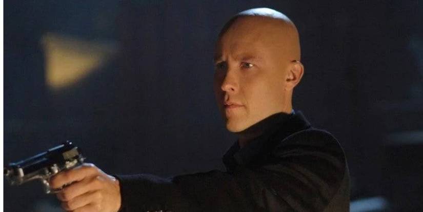 Michael Rosenbaum como Lex Luthor apontando uma arma em Smallville