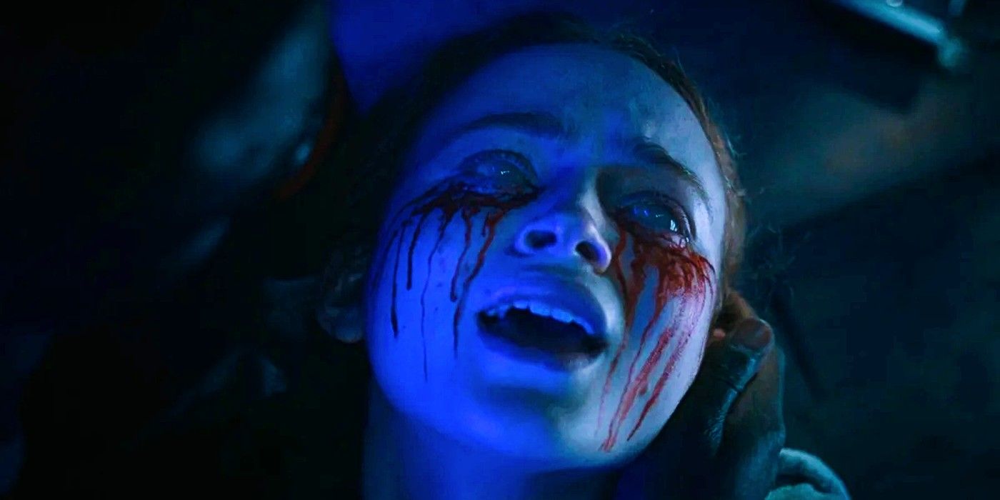 Sadie Sink as Max with bleeding eyes lying in Lucas' arms in Stranger Things season 4