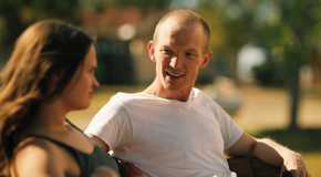 Jefferson White talks to Kathryn Kelly while they sit on a bench in Yellowstone