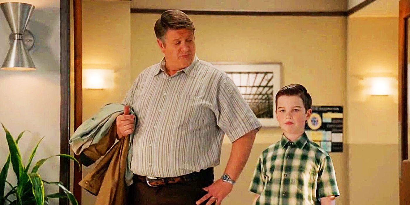 George with a hand on his hip looking down at Sheldon next to him in Young Sheldon.