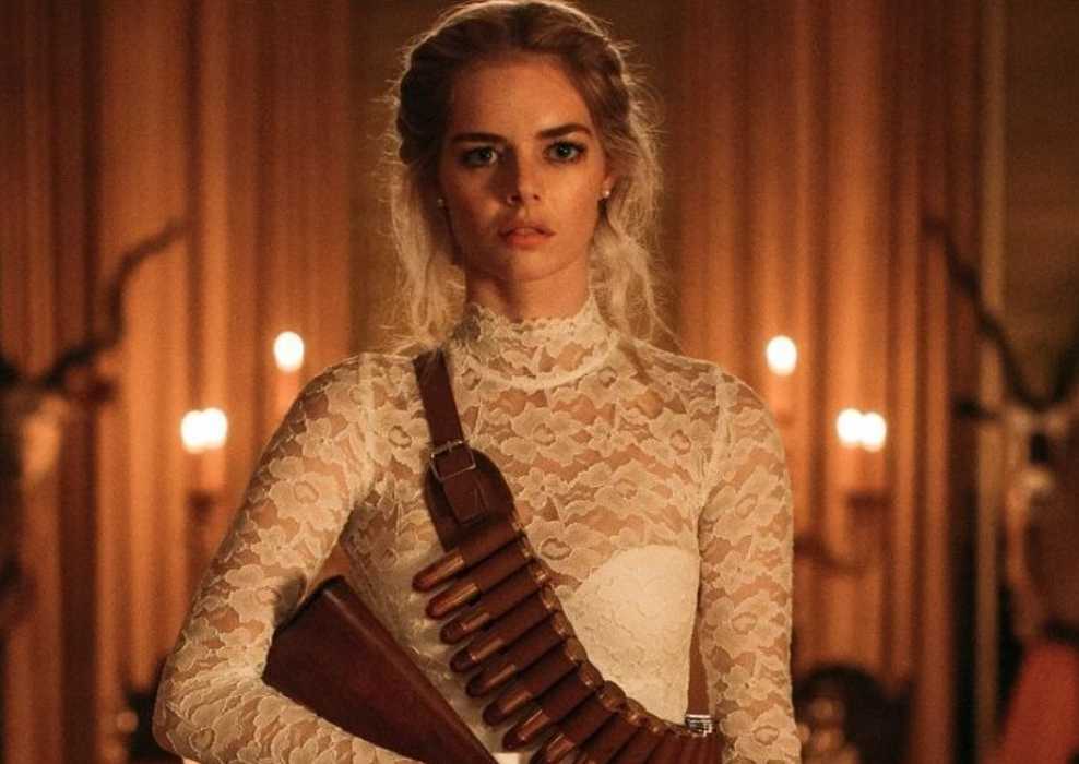 Grace (Samara Weaving) armed for the hunt in Ready or Not wearing her bridal dress