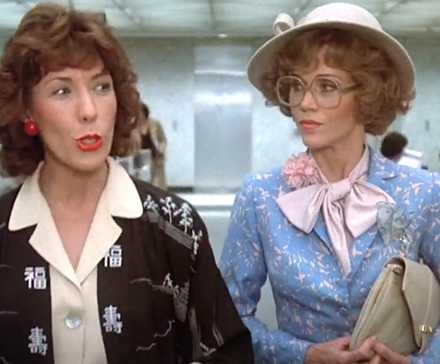 Лили Томплин и Дженнифер Фонда в фильме "Nine to Five", совершающие прогулку и беседу в оживленном офисе
