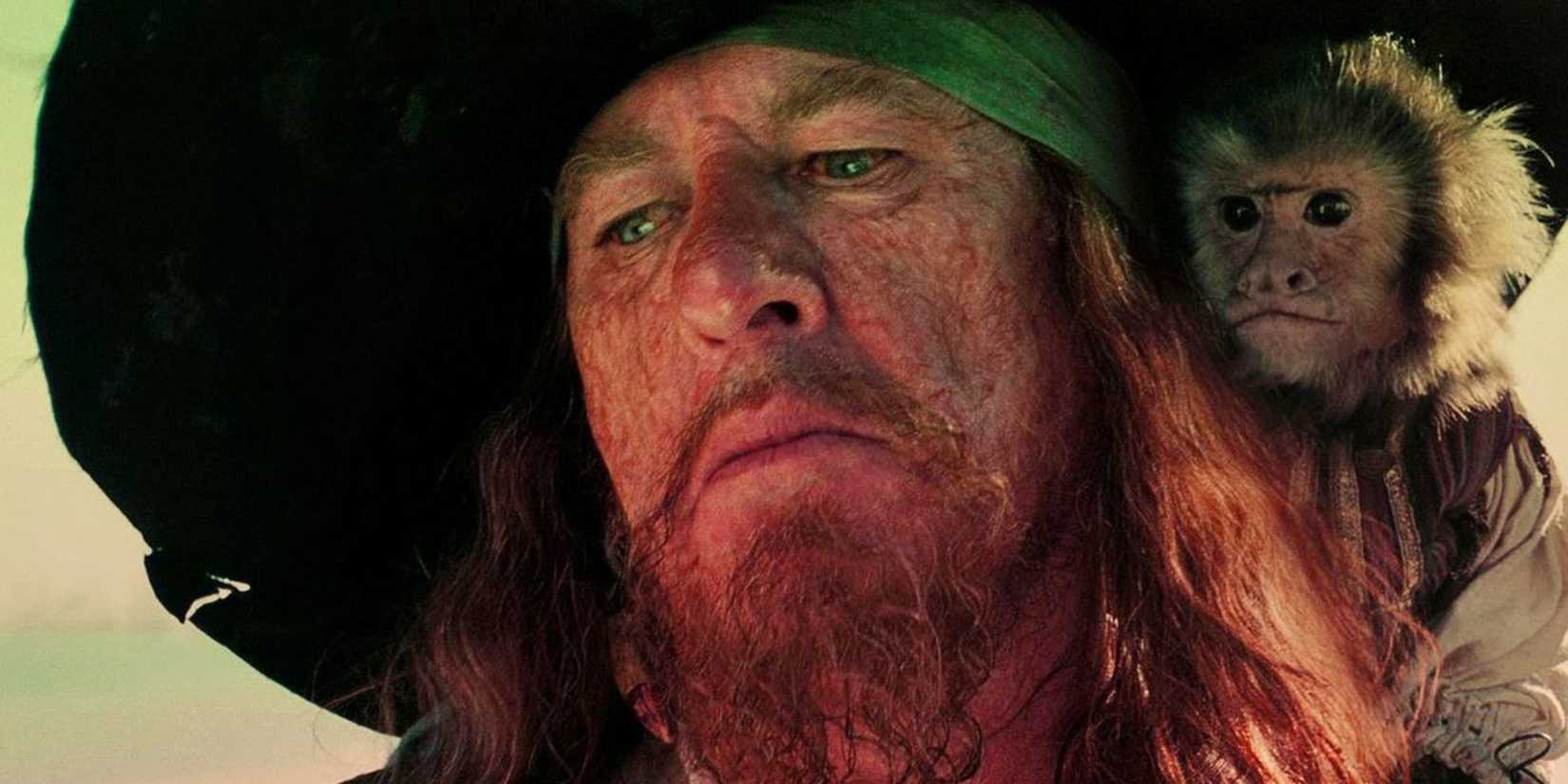 Hector Barbossa looking down with his monkey on his shoulder in Pirates of the Caribbean