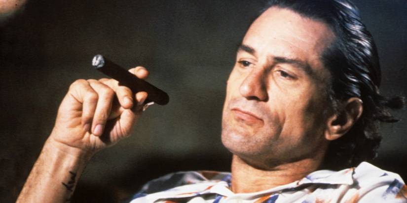 Robert De Niro as Max Cady with a cigar in a movie theater In Cape Fear