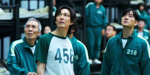  Lee Jung-jae as Gi-hun looking up at the ceiling with other contestants in Squid Game