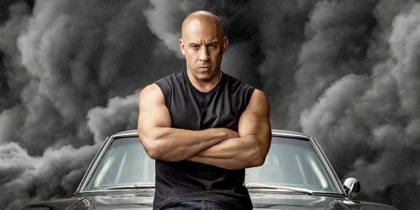 Dominic Toretto cruza os braços em frente à fumaça preta de Velozes e Furiosos 