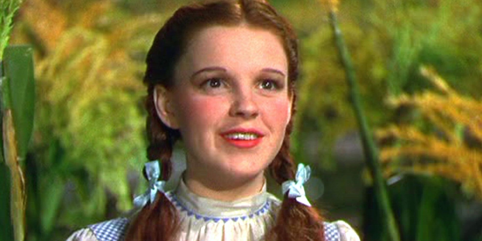 Dorothy (Judy Garland) smiling in a corn field in The Wizard of Oz (1939).