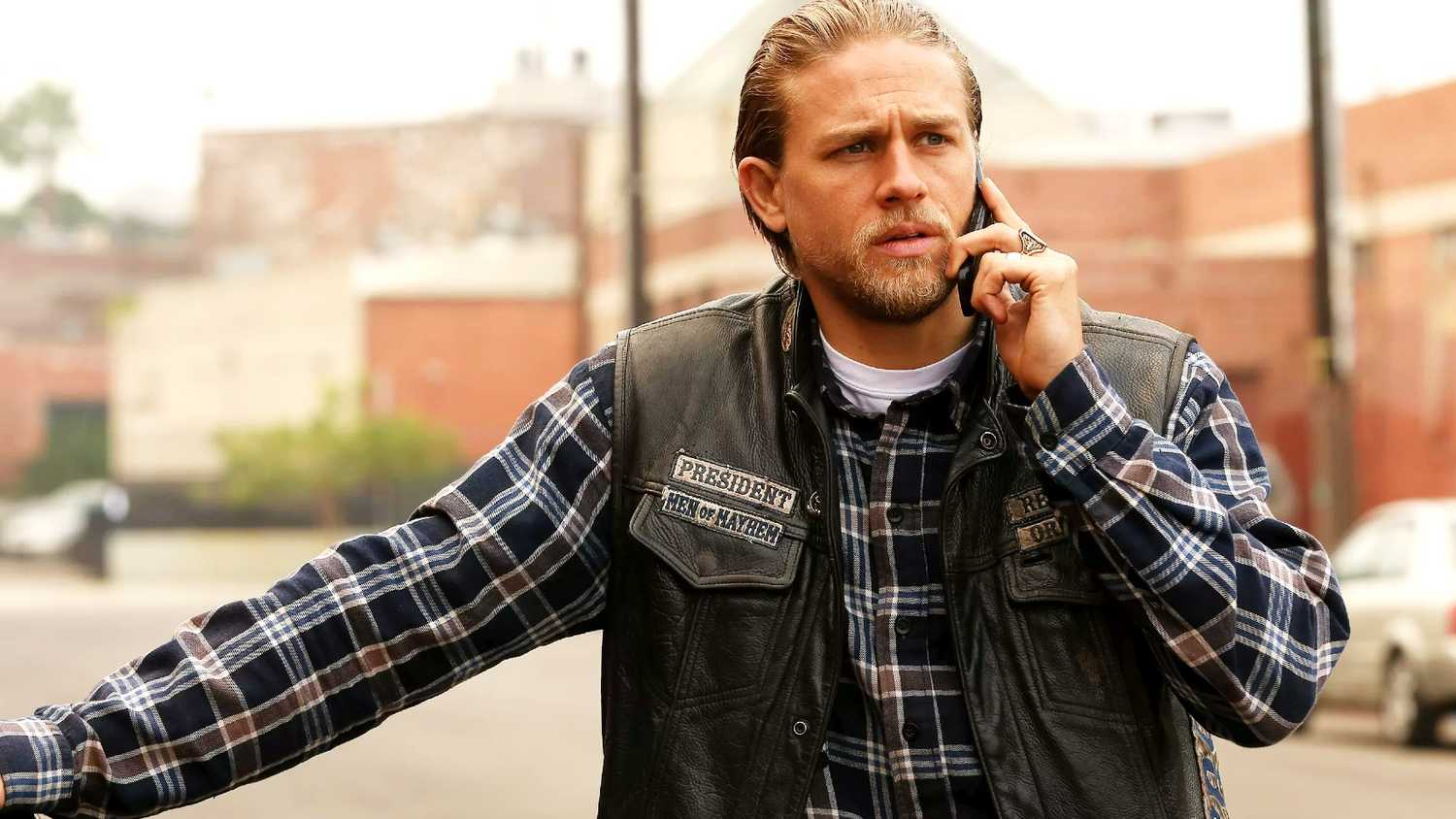 Jax (Charlie Hunnam) talking on the phone with someone in Sons of Anarchy