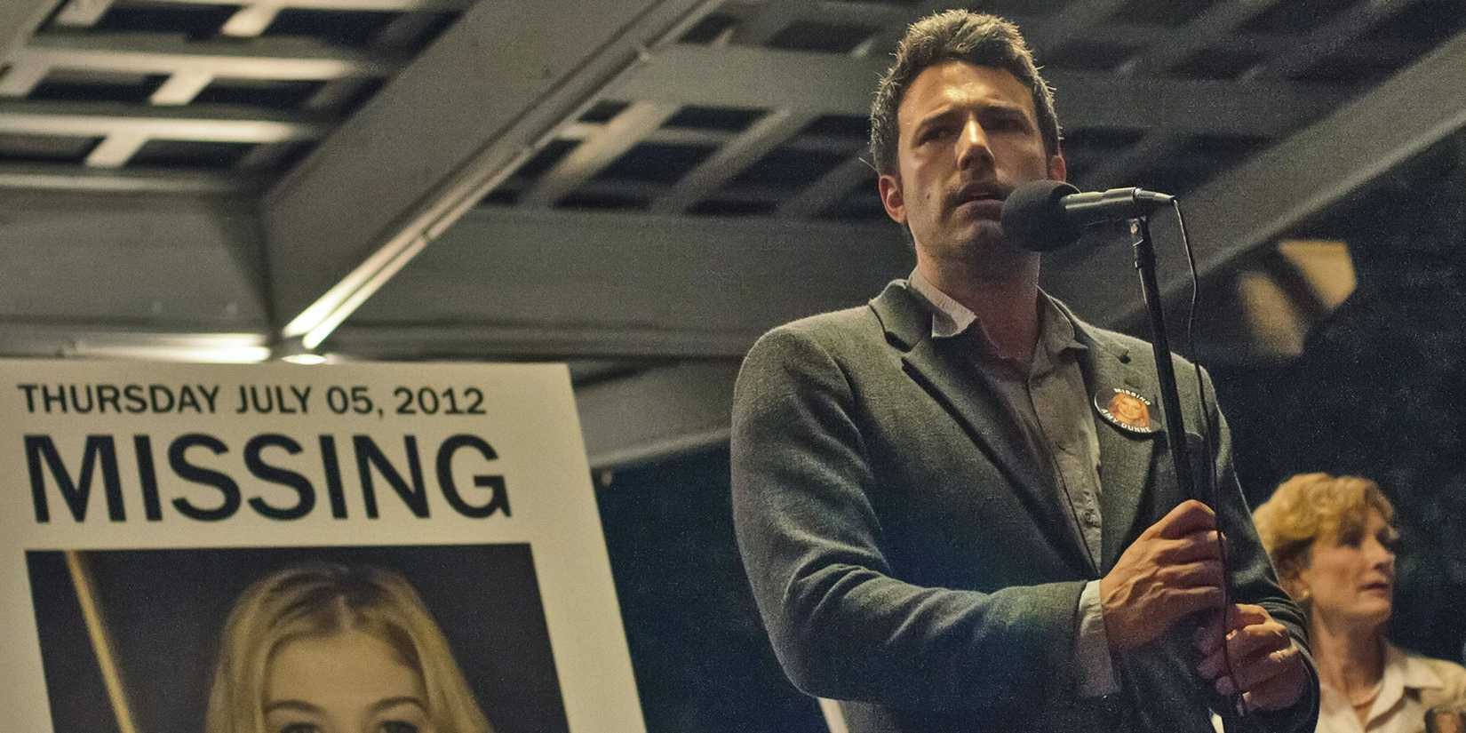 Ben Affleck as Nick in front of Amy's missing poster in Gone Girl