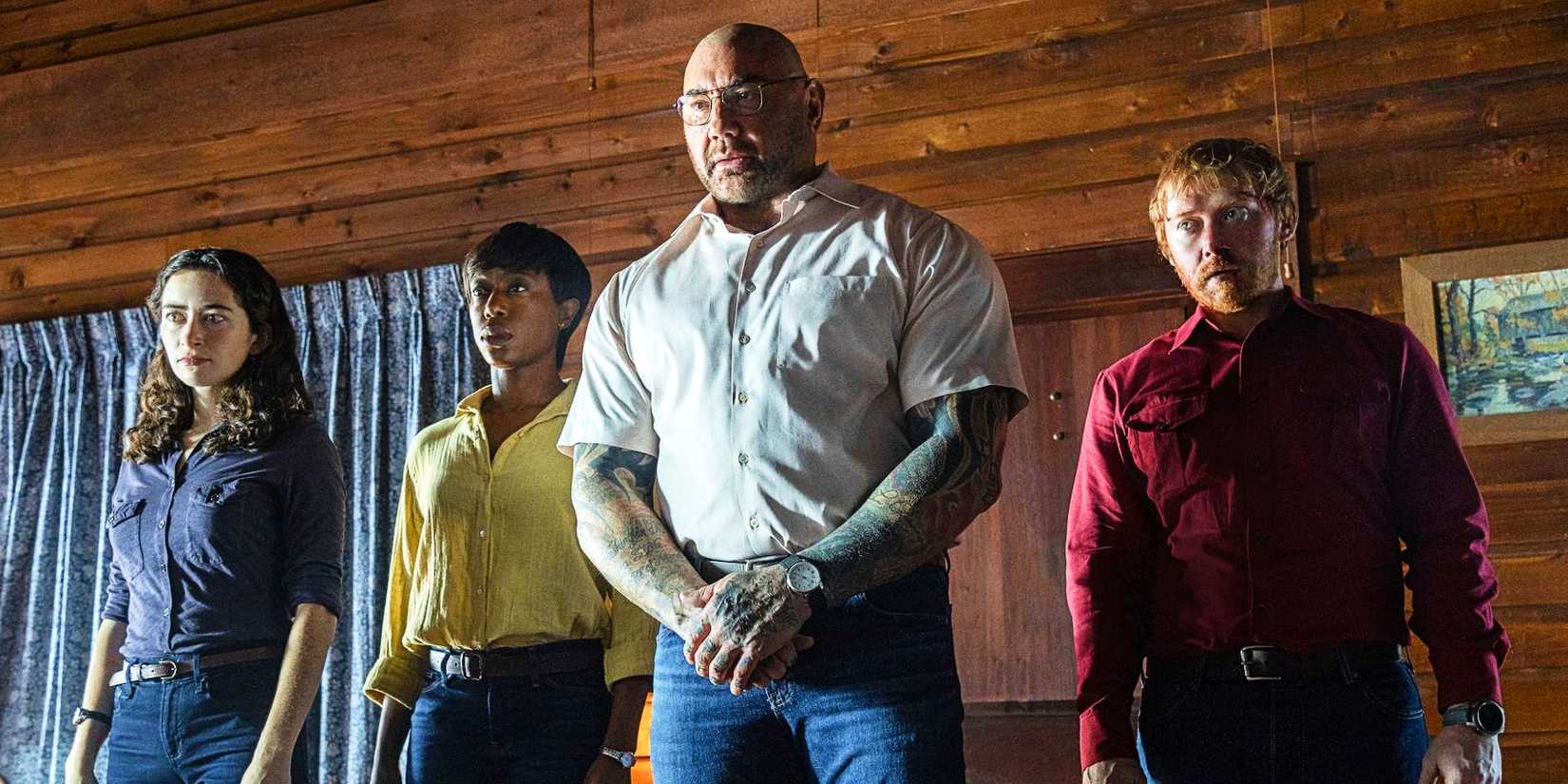The Doomsayers standing in a line in Knock at the Cabin