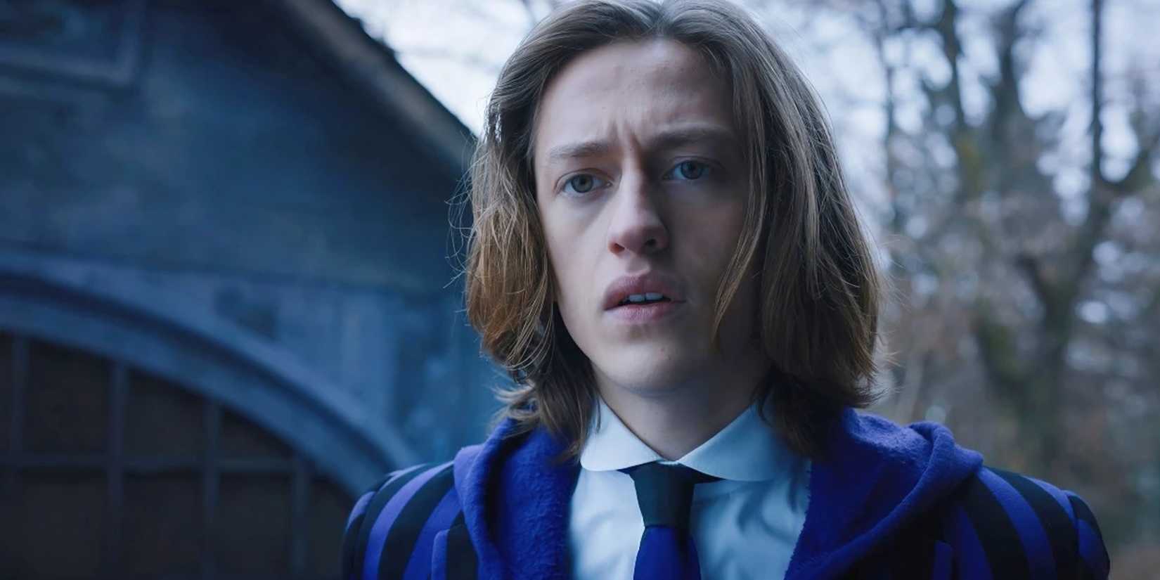 Percy Hynes White como Xavier parecendo preocupado na quarta-feira em uniforme escolar