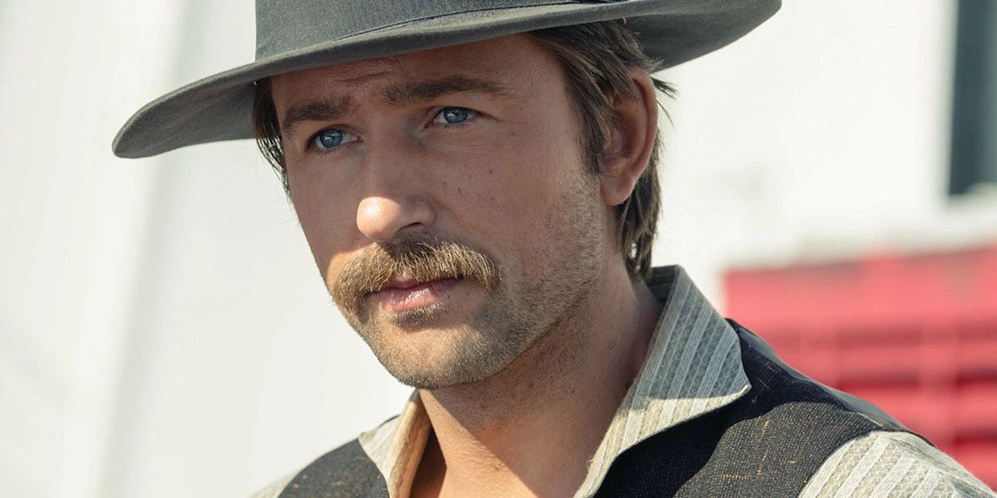 Brandon Sklenar as Spencer in 1923 season 1 wearing a hat and gazing pensively with his penetrating blue eyes