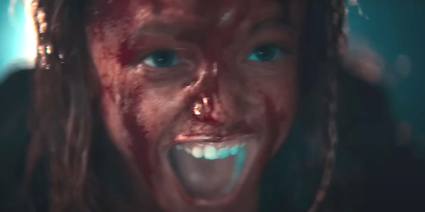 Nell Fisher as Kassie in Evil Dead Rise, her face smeared with blood, screaming in terror