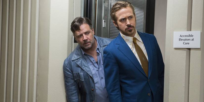 Ryan Gosling e Russell Crowe espiam por uma esquina em The Nice Guys