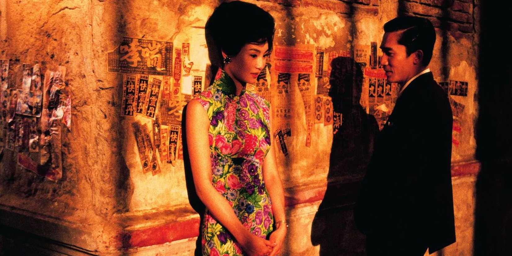 Maggie Cheung как Су Ли-джен и Tony Leung как Чоу Мо-ван говорят в драматически освещенном переулке в In the Mood for Love
