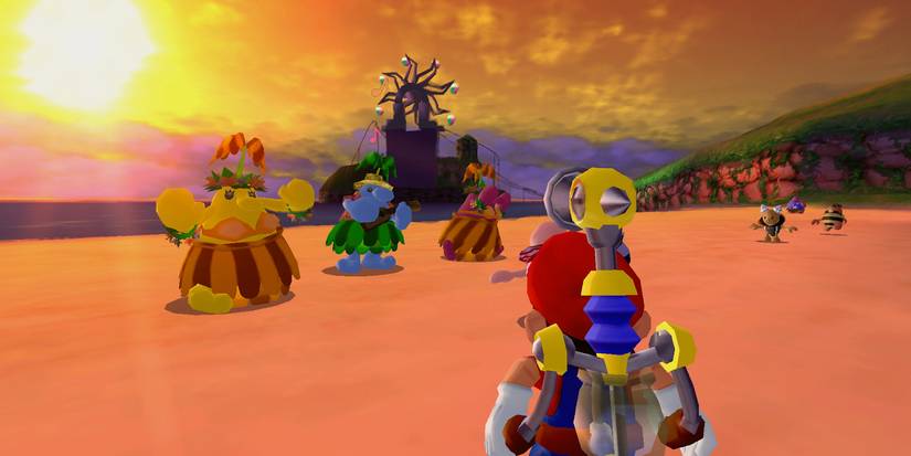 Mario stands on an idyllic, orange-lit beach at sunset, watching three Piantas in grass skirts dance.