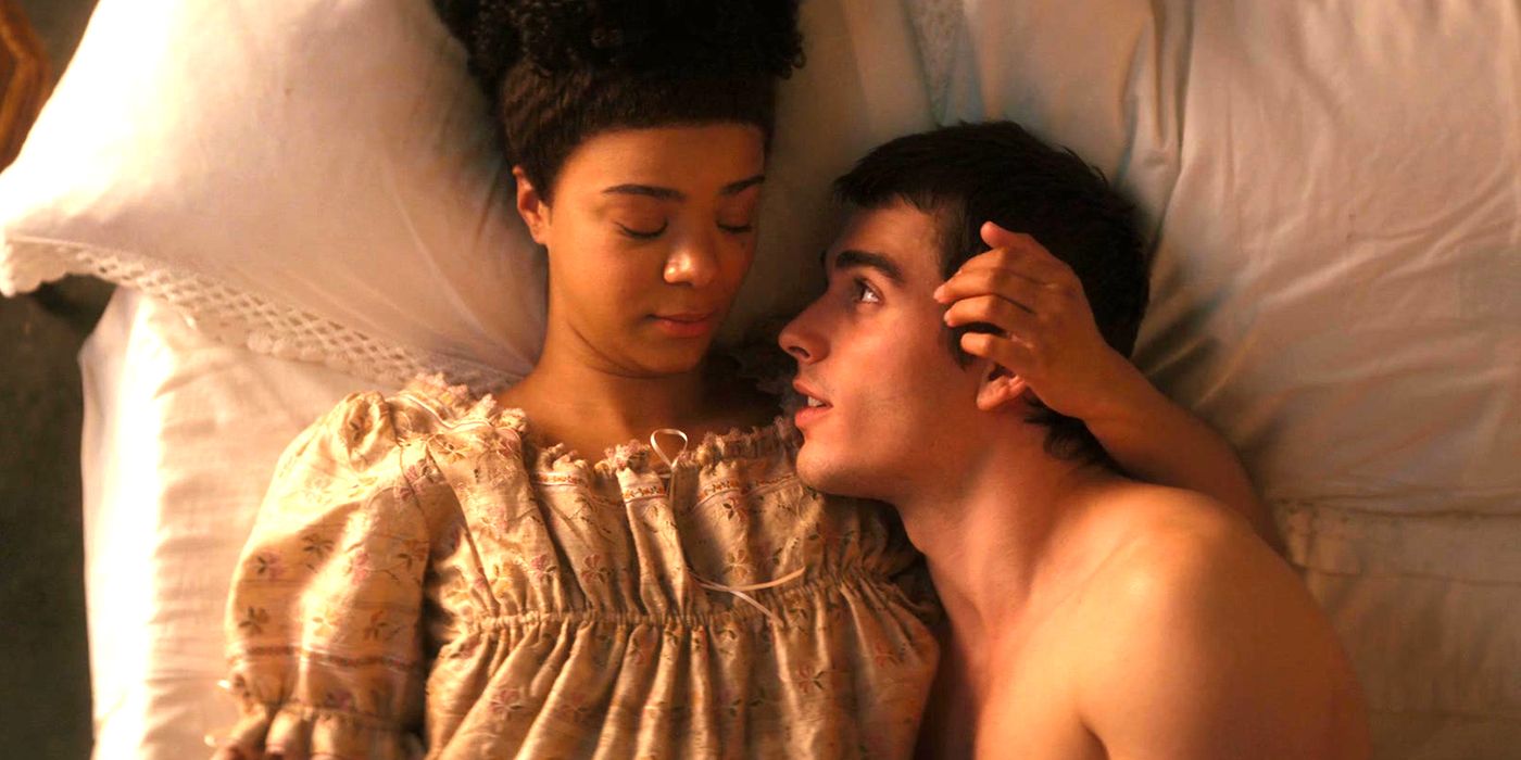 India Amarteifio and George Mylchreest lay on a bed in Queen Charlotte: A Bridgerton Story