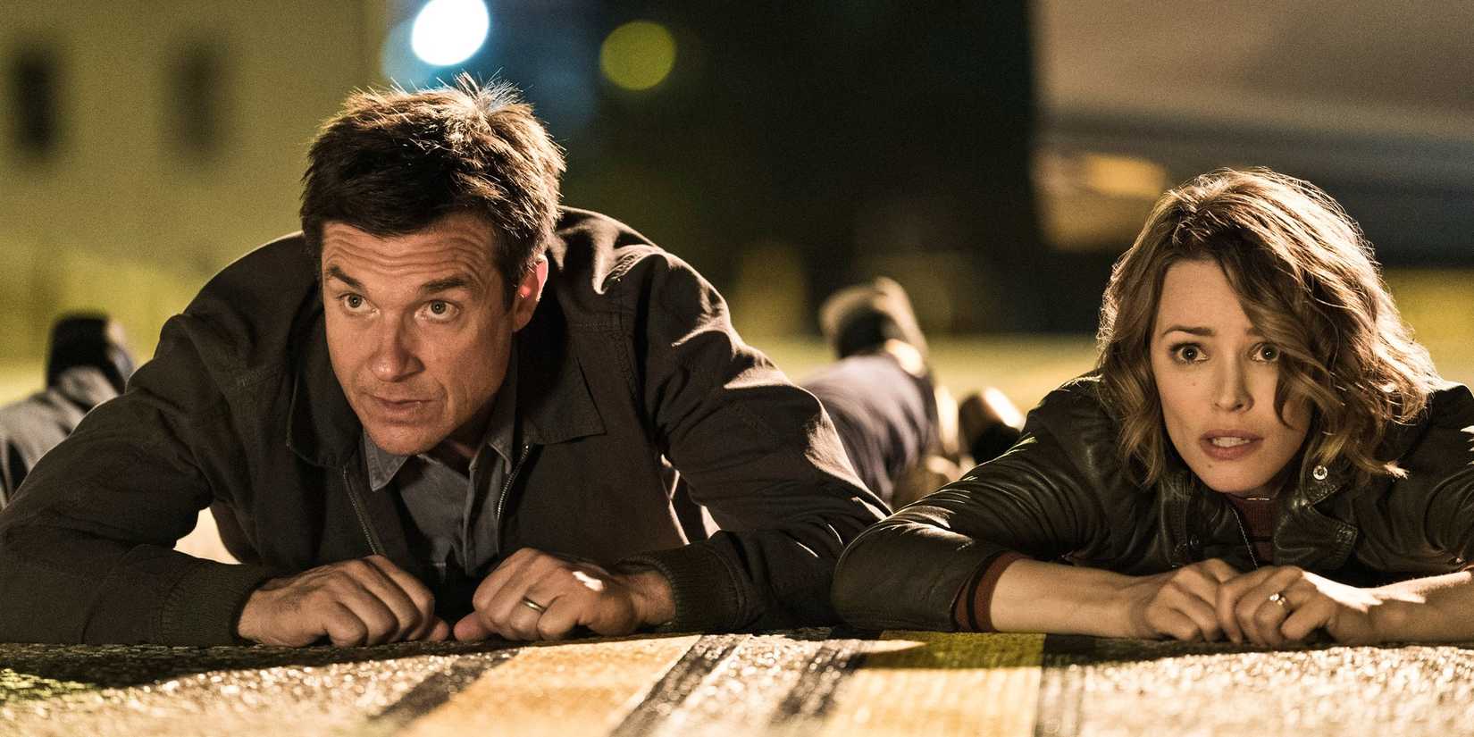 Max (Jason Bateman) and Annie (Rachel McAdams) lie on the road in Game Night