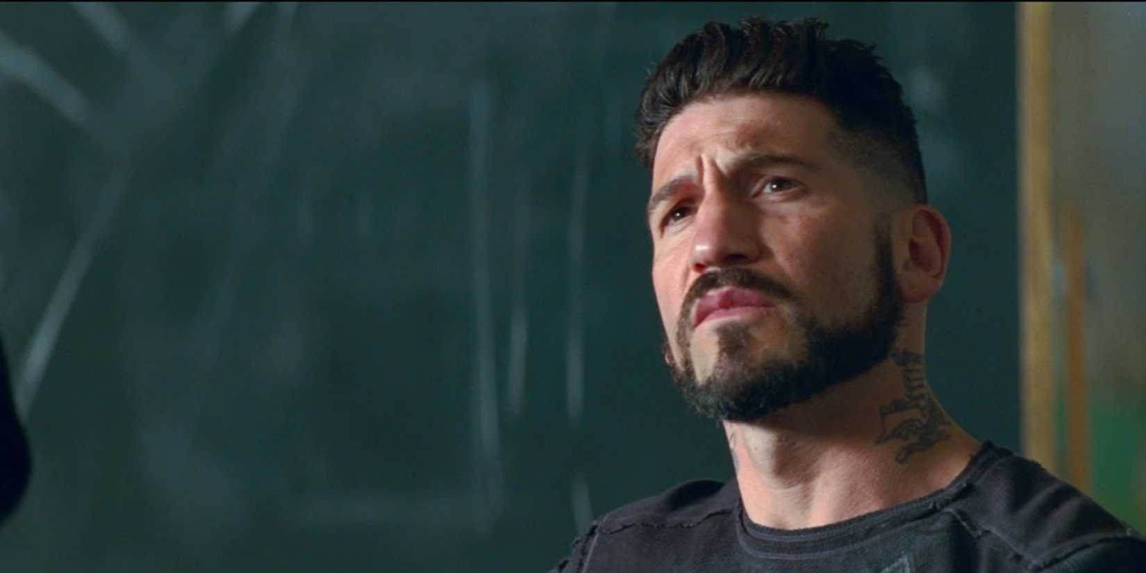 Griff (Jon Bernthal) sentado perto de um quadro negro em Baby Driver