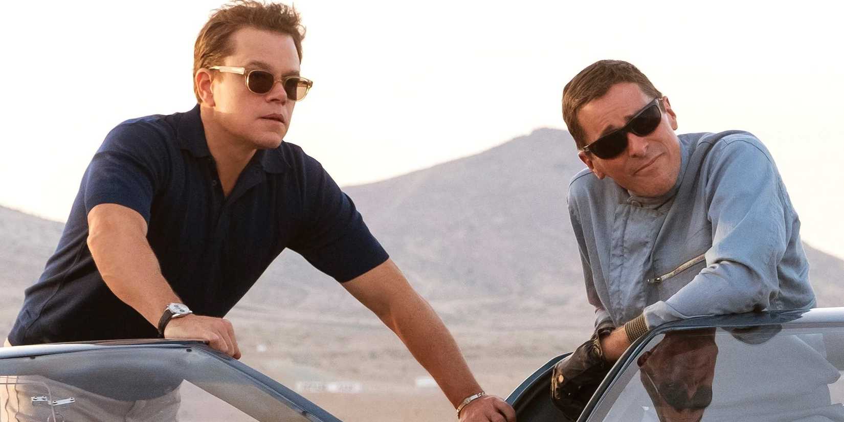 Matt Damon and Christian Bale lean against a car in Ford v Ferrari.