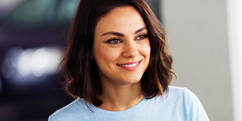 Mila Kunis smiling while looking to the side