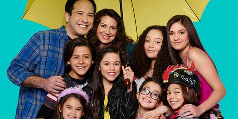 O elenco de A Família Diaz posando sob um guarda-chuva.