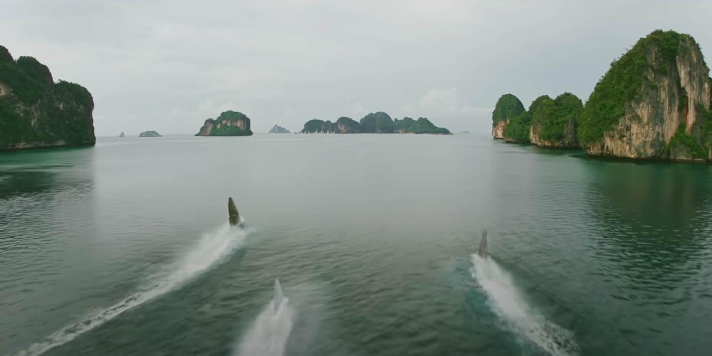 https://static0.srcdn.com/wordpress/wp-content/uploads/2023/05/three-shark-fins-in-meg-2-the-trench-s-trailer.png