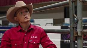 Jimmy Hurdstrom in his 6666 shirt and leaning against a fence at the rodeo in Yellowstone